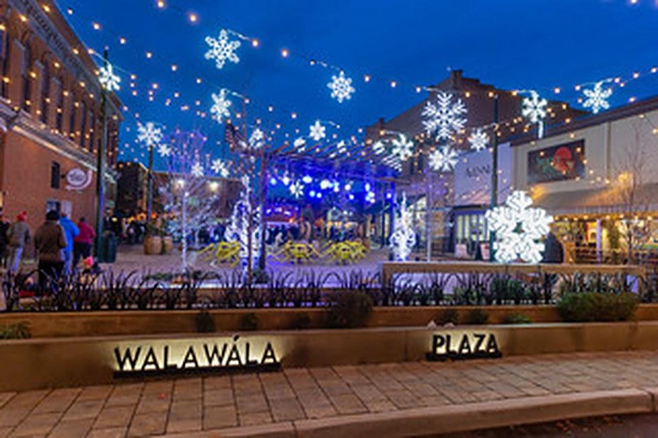 Giant lit snowflakes strung over the Walla Walla Plaza at dusk.